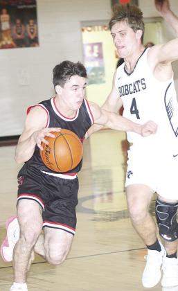 P.C.’s Jett Farwell (left) drives past an E-M-F defender early in the game on Saturday. Farwell finished the game with 12 points. Paula Jasa/Republican