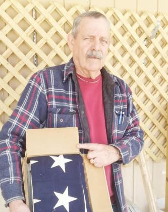 Picture of Lee Malmos attached when donated the cardboard box with the flag and other mementos.