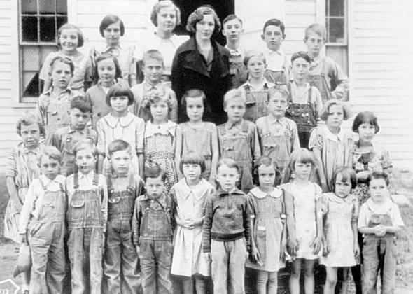A traveling photographer took a school picture of the students on the front steps of the Maple Grove Country School. Bernice Marfice is the little girl in the front row, second from the right. The teacher was Marcella Klein Wheeler, then unmarried.