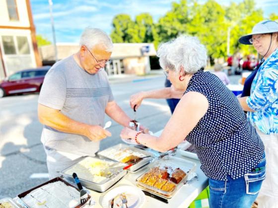 Arts Council board member Billie Kay Bodie of Burchard serves Larry Gilbert of Table Rock